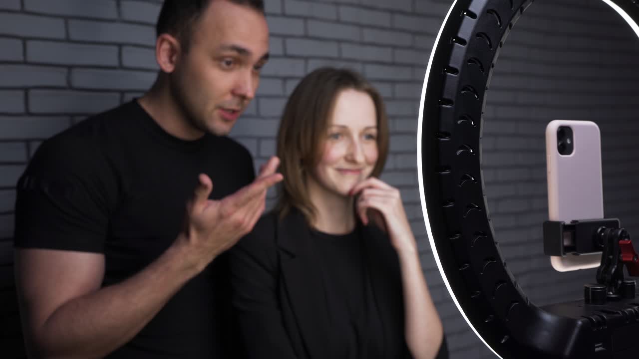 imágenes de una pareja con un teléfono inteligente en el fondo de una pared de ladrillo