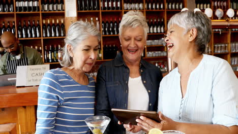 amigos mayores usando tableta digital mientras tienen cóctel 4k