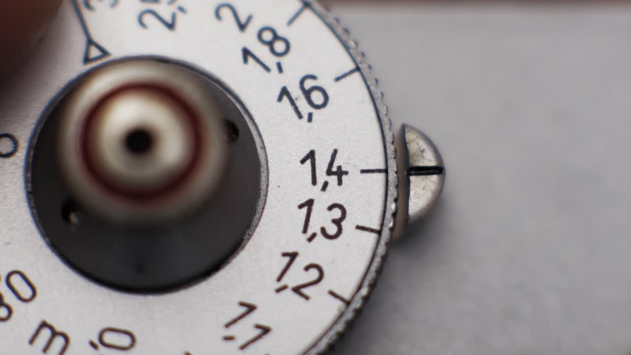 Macro view of silver rangefinder dial measuring focus distance