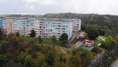 Aerial-pan-right-shot-capturing-apartment-blocks-painted-with-pastel-colors-in-Siriusgatan,-Bergsjon,-Gothenburg