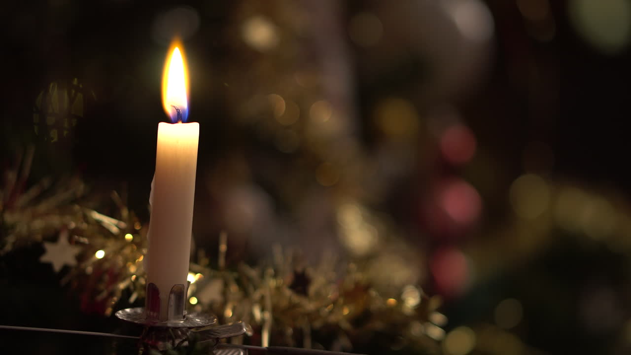 Lighting a candle, mounted on a christmas tree in 4K.