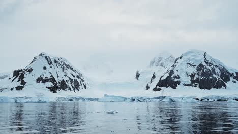 Aerial-drone-shot-of-Antarctica-Landscape,-Glacier-and-Mountain-Scenery-on-the-Antarctic-Peninsula-in-the-Southern-Ocean,-in-a-Snow-and-Ice-Covered-Landscape-in-Cold-Weather