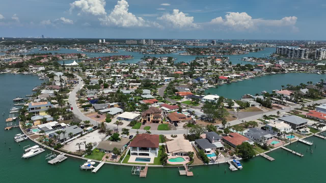 Aerial view of Treasure Island, Florida. Vibrant coastal neighborhood with boats lining canals, lush greenery and clear blue skies. Scenic waterfronts with hotels and homes in America.