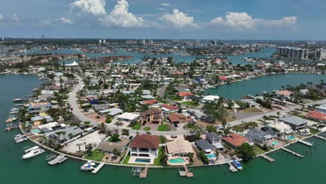 aerial view of treasure island, florida. vibrant coastal neighborhood with boats lining canals, lush greenery and clear blue skies. scenic waterfronts with hotels and homes in america.