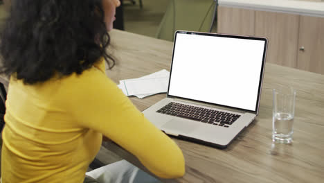 Biracial-businesswoman-using-laptop-for-video-call-with-copy-space