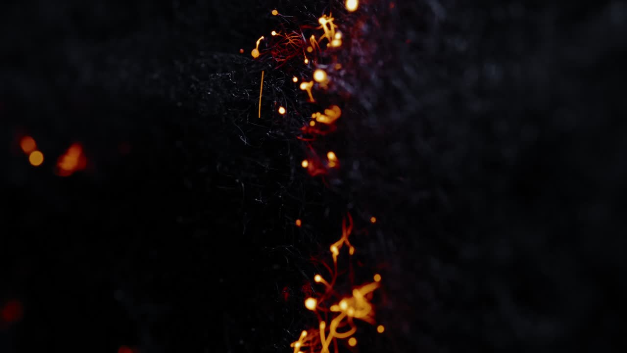 ARTISTIC FIRE TRAILS: A few small sparks ignite the left side of the frame and soon form a wall of fire spreading to the right, burning everything along their way