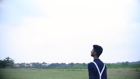 boy or man walks in grassland and looks up in sky in surprise, sky can be replaced into anything