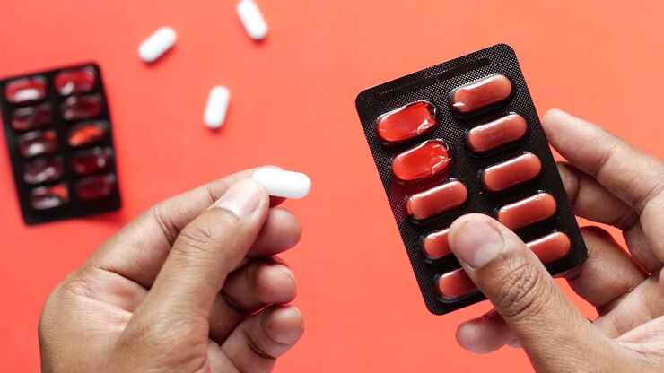 Close up of man holding blister packs
