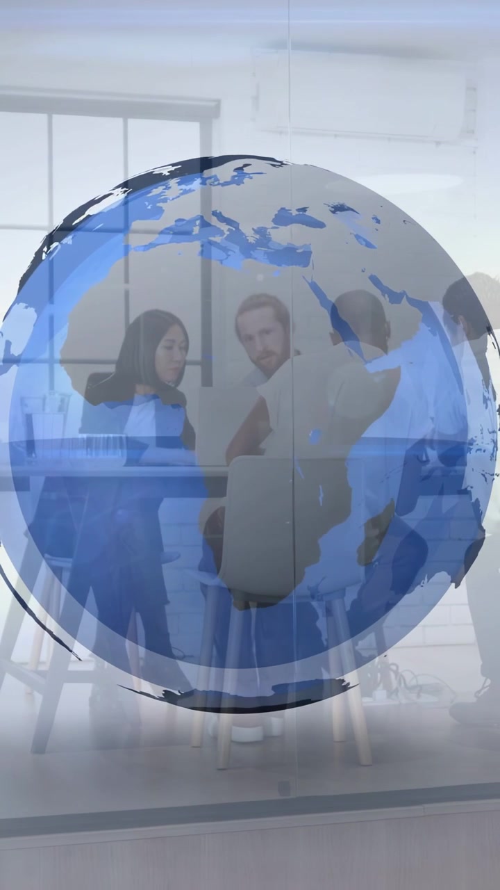 Video vertical: Equipo tocando una tableta y discutiendo un plan global en una reunión, con un globo terráqueo superpuesto en la mesa.