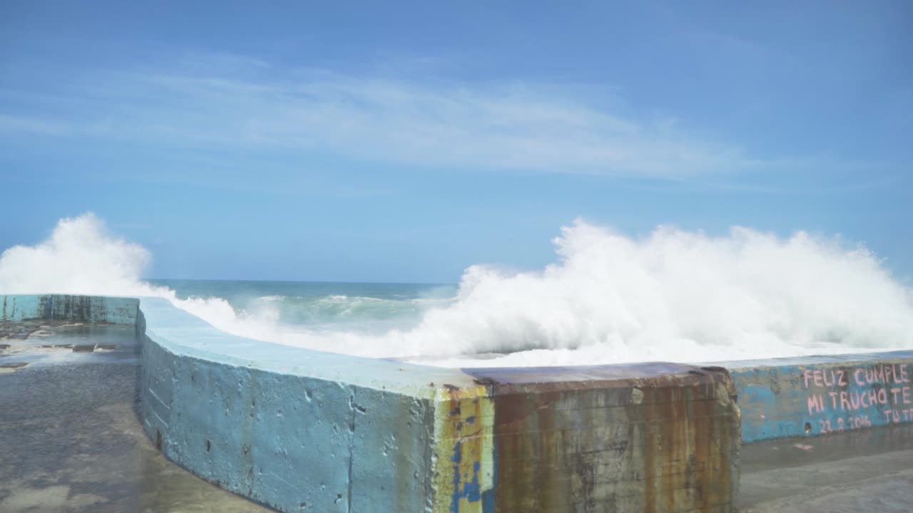 las olas del océano chocando contra una pared de hormigón