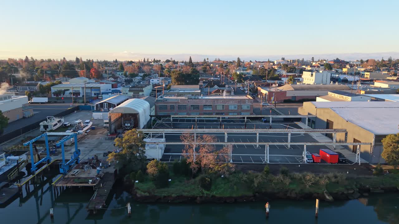 Dall'alto del Tidal Canal, una ripresa aerea con drone del quartiere intorno alla zona di Blanding Ave si apre con strade ordinate, bordi del lungomare e un tranquillo fascino, catturando una vista radicata di Alameda