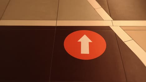 Motion around white arrow in red circle on tiled floor