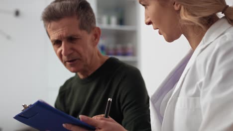 senior man makes talking with doctor in waiting room.