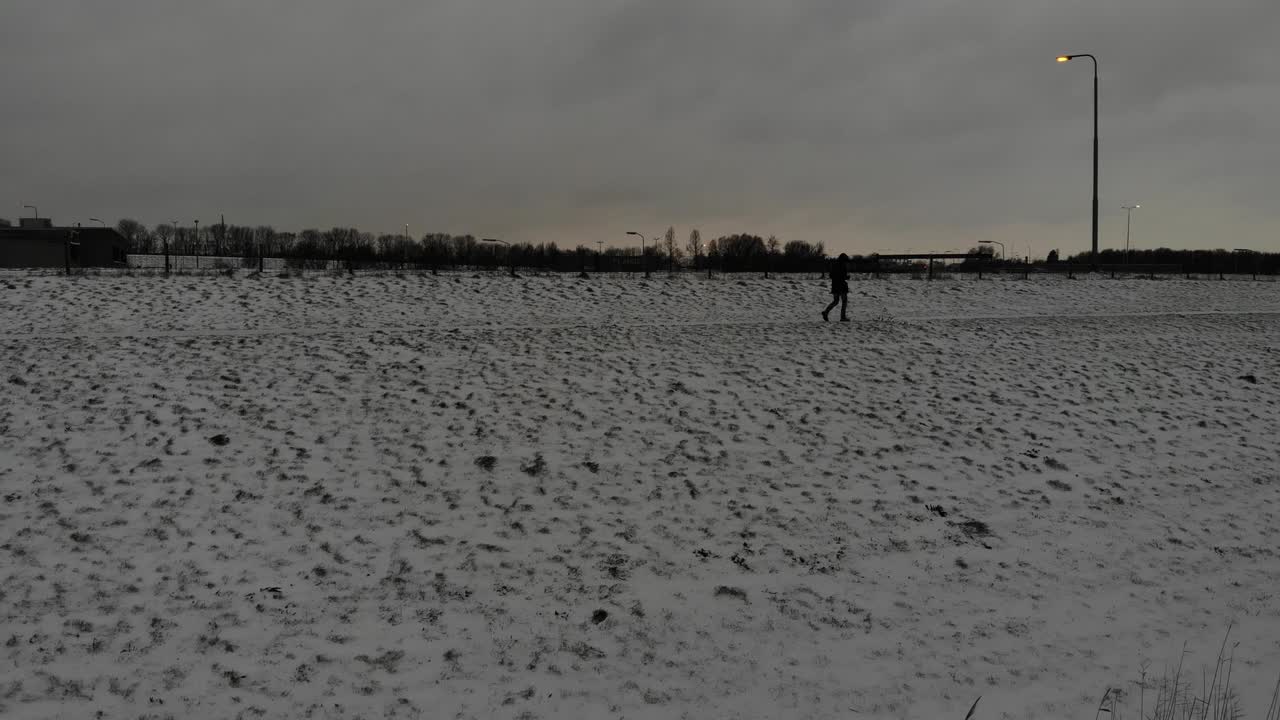 Lone Person Walks Through Winter Countryside At Dusk