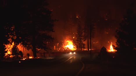 firefighters driving on a road in middle of raging forest fires, during nighttime