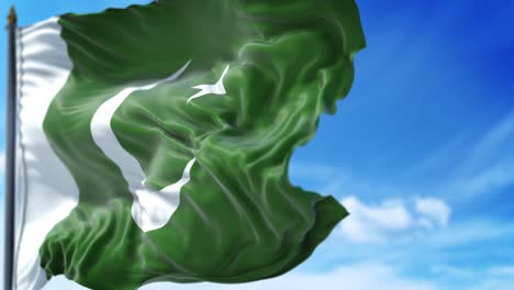 la bandera de pakistán está ondeando lentamente contra el cielo azul.