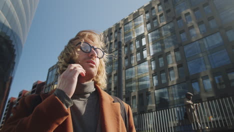 businessman standing in city and talking on phone