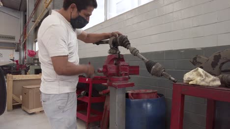 Macho-Latino-Técnico-Arreglando-El-Eje-De-Transmisión-De-Un-Automóvil-En-Un-Garaje-De-La-Estación-De-Taller-En-México-América-Latina