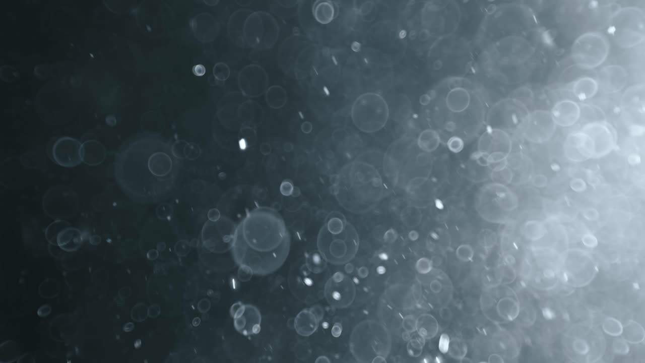 Floating abstract particle bokeh on dark background