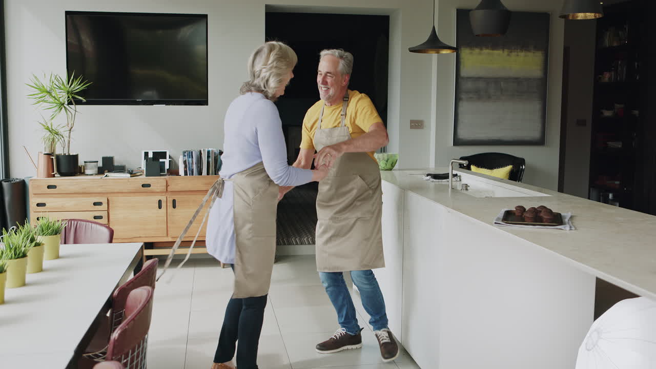 Senior couple dancing in their kitchen