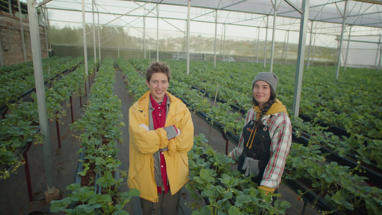 Young Female Workers Posing Together in Greenhouse Farm