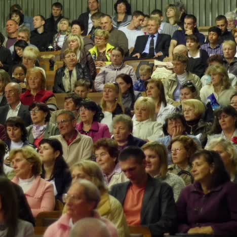 crowd of people to sitting and listening in a large hall