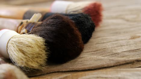 various paint brushes on wooden table