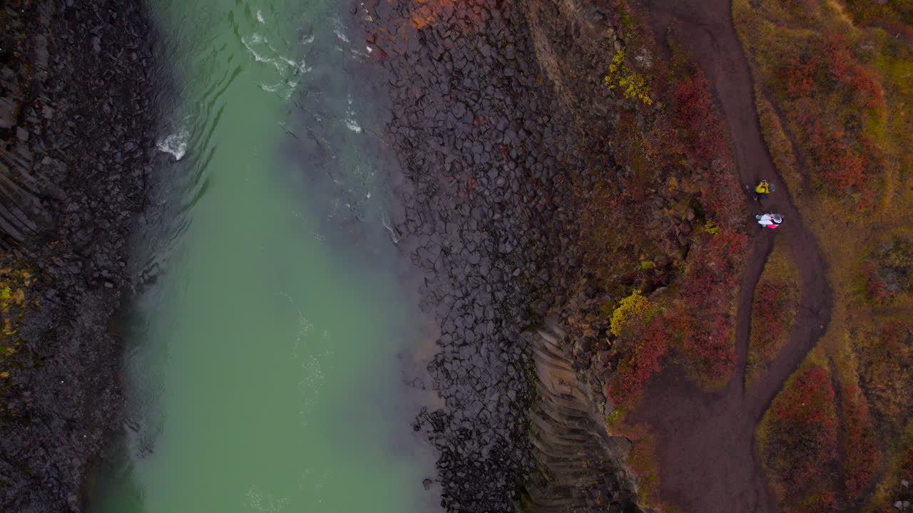 남자 와 여자 가 아이슬란드 의 화산 캐니언 인 스터드라길 을 탐험 하고 있다