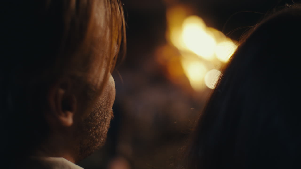 Close-up of a man's profile in a dark setting with bokeh lights