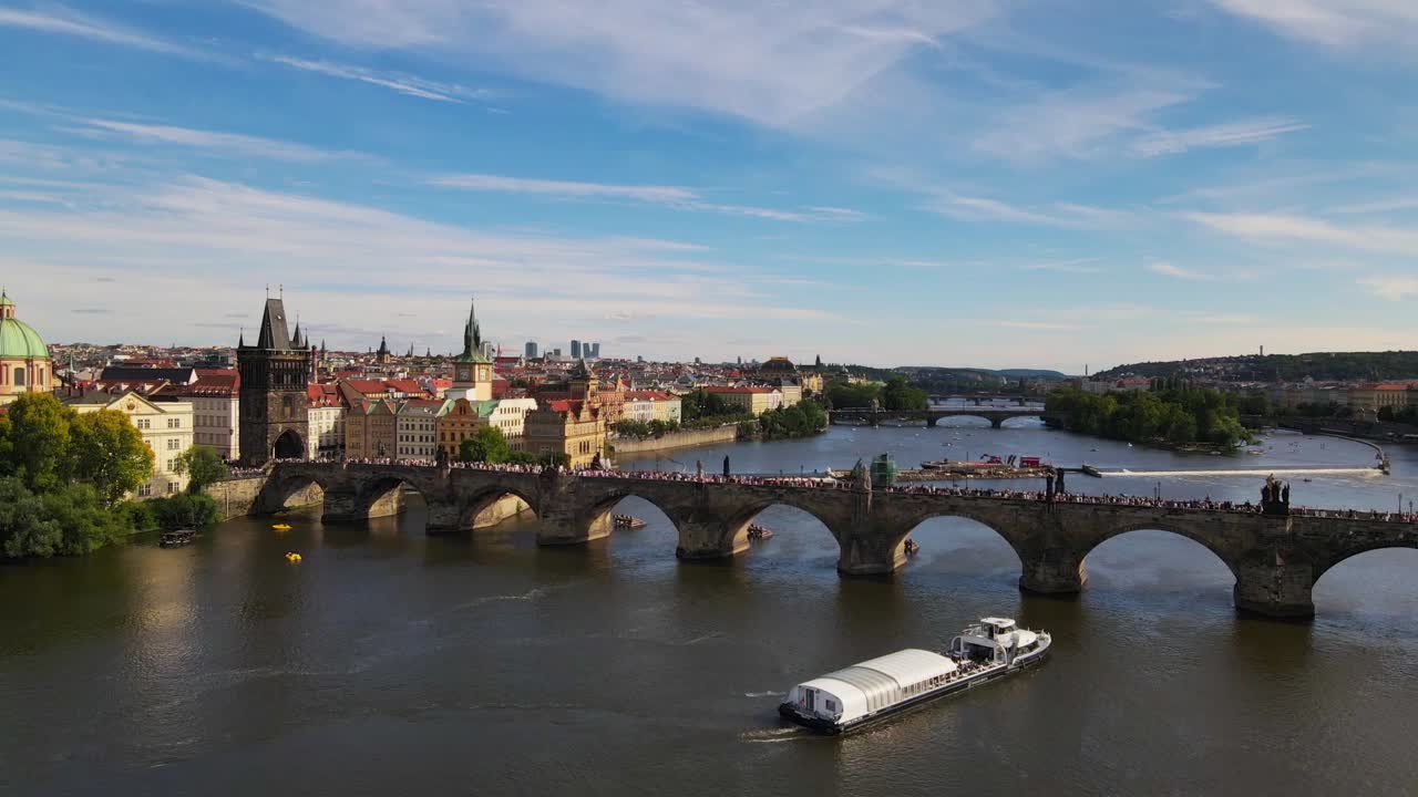 Aerial footage of Prague's iconic Charles Bridge spanning the Vltava River, capturing the historic architecture and scenic beauty of this renowned European landmark.