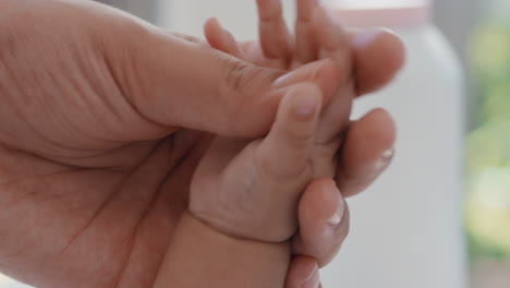 de cerca la madre sosteniendo al bebé con la mano tocando los dedos la madre cuidando al recién nacido cuidando del bebé en casa el amor de la maternidad 4k