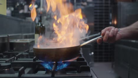 el cocinero está trabajando con la sartén
