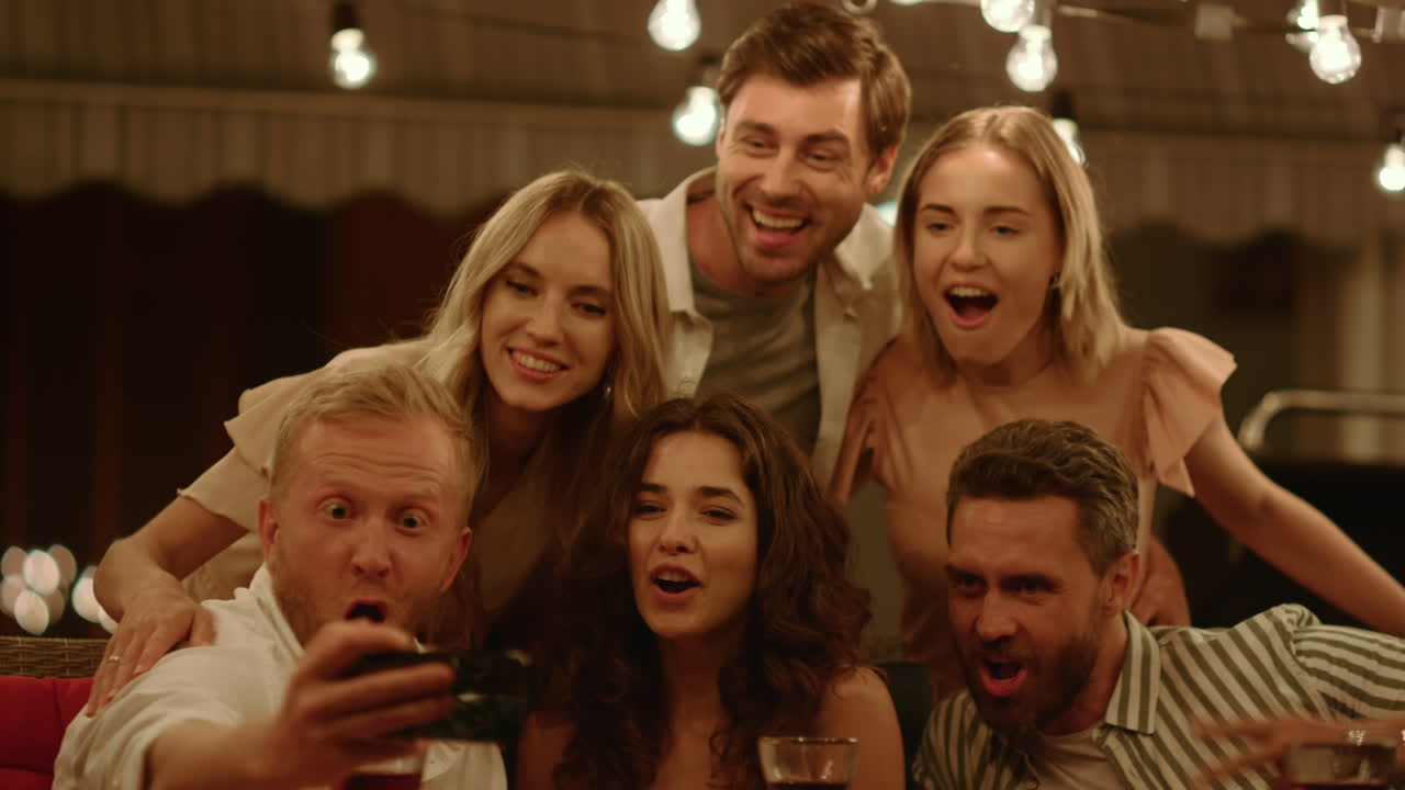 행복한 친구들이 스마트폰으로 셀피 사진을 찍습니다.