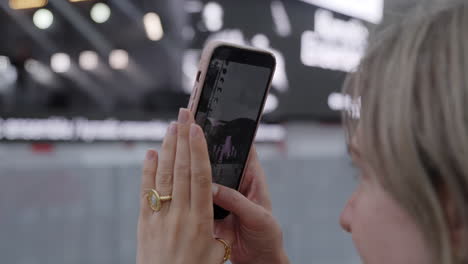 woman taking a photo with her phone at a market