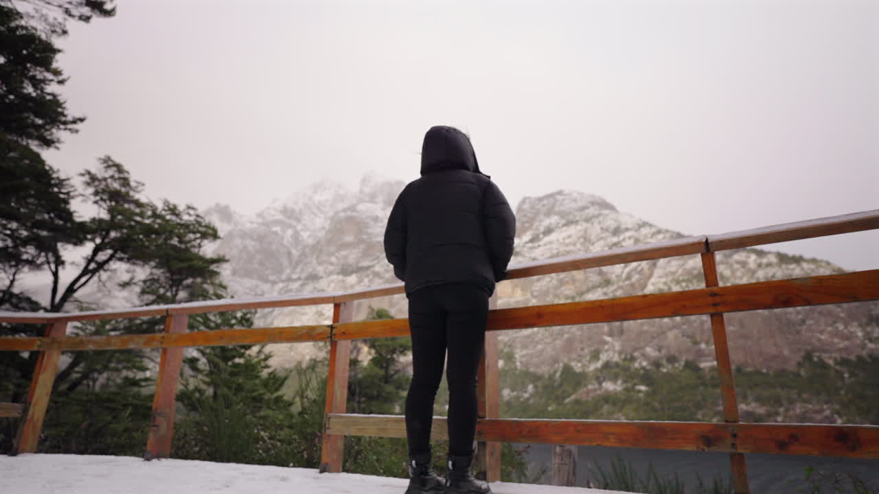 Contemplating nature on a person view while looking at snow covered mountain peaks in background, Bariloche, Argentina.