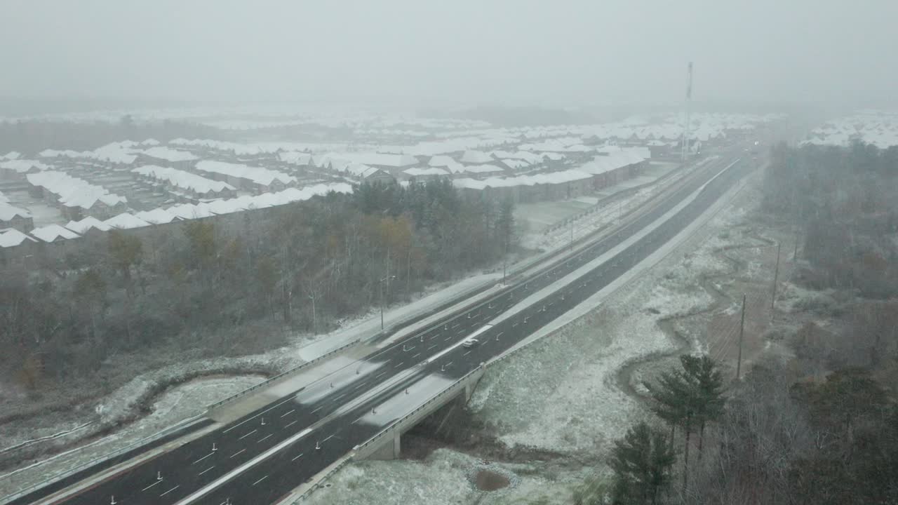 리치몬드 힐 근처의 강한 눈보라 동안 고속도로에서 운전하는 자동차의 공중 촬영