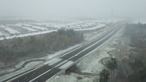 aerial shot of a car driving on a highway during a strong blizzard near richmond hill