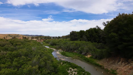 Mountain-river-with-rocks-and-trees-around,-aerial-drone-view