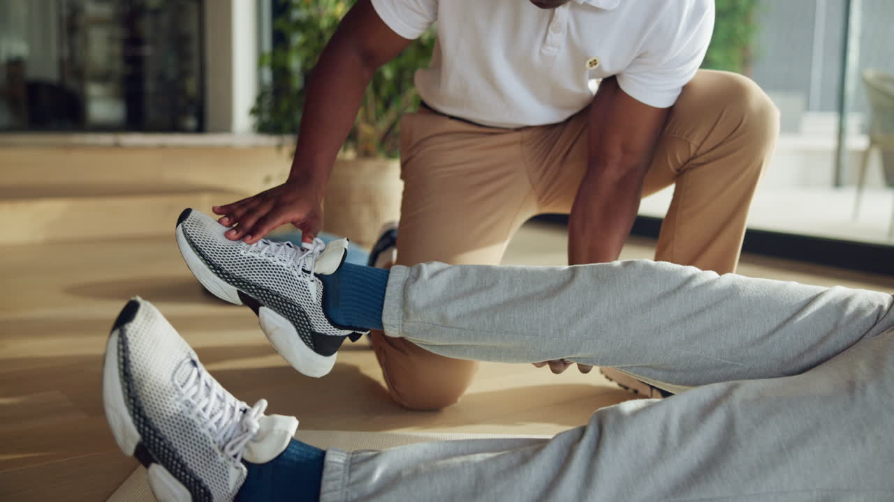 Un physiothérapeute aide un patient à faire des exercices de jambe pour sa rééducation