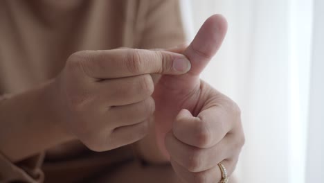 mujer masajeando su pulgar