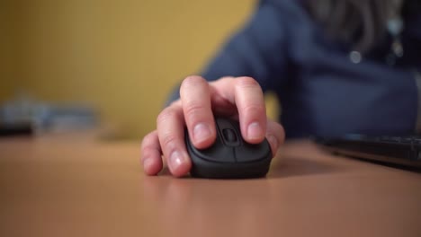 Woman-using-laptop-at-home-holding-mouse-clicking