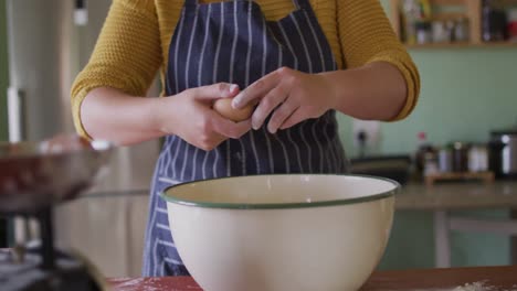 sección media de una mujer caucásica horneando en la cocina