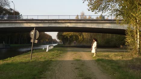 woman standing still in the sun, taking a break from her autumn walk