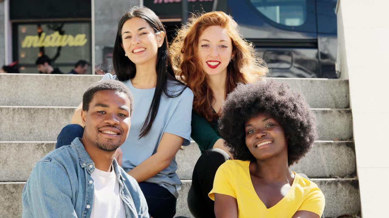 Diverse group of young adults smiling on steps
