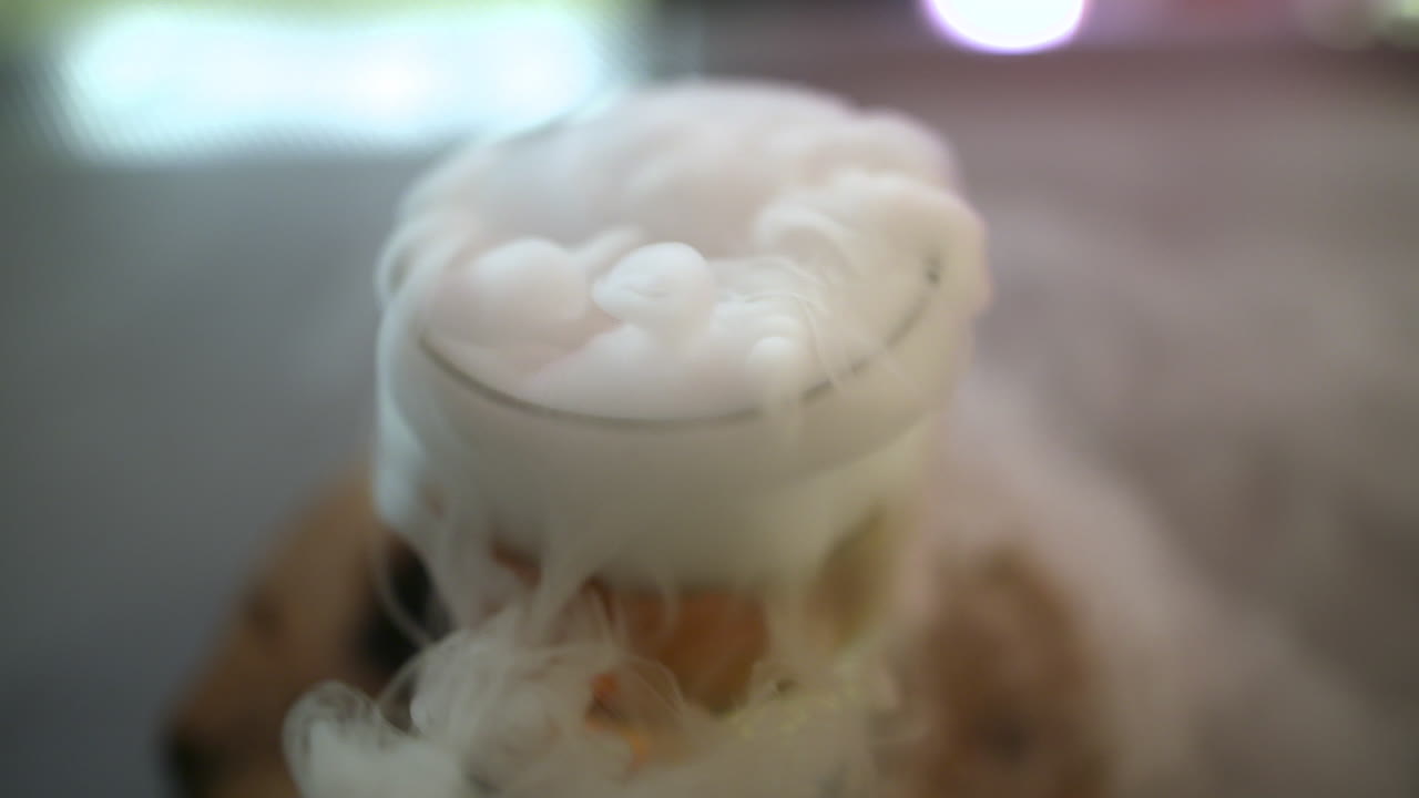 Dry Ice Emerging From A Fresh Drink Prepared By A Bartender