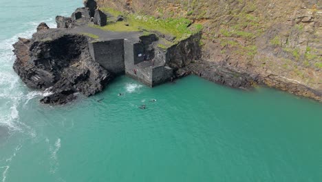 tourists at the popular spot for cliff-diving at blue lagoon - abereiddi in wales, united kingdom. aerial shot