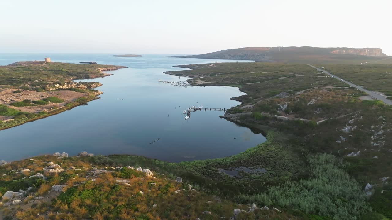 panorámica aérea del paisaje de pastizales y barcos atracados en sa nitja menorca, españa