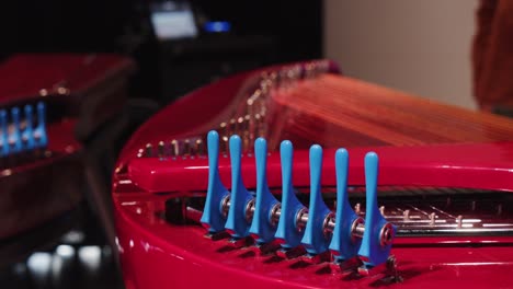 Wide-shot-of-toggles-on-a-red-harpsichord-instrument