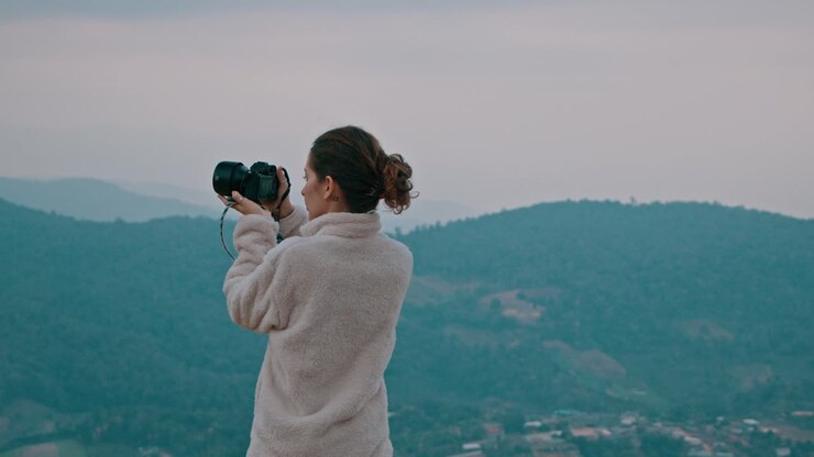 Woman Taking Pictures of a Mountain Landscape