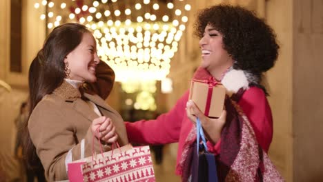two women exchanging gifts during the holiday season